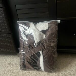 Dark brown leather women’s western sleek winter coat with white fur linings.